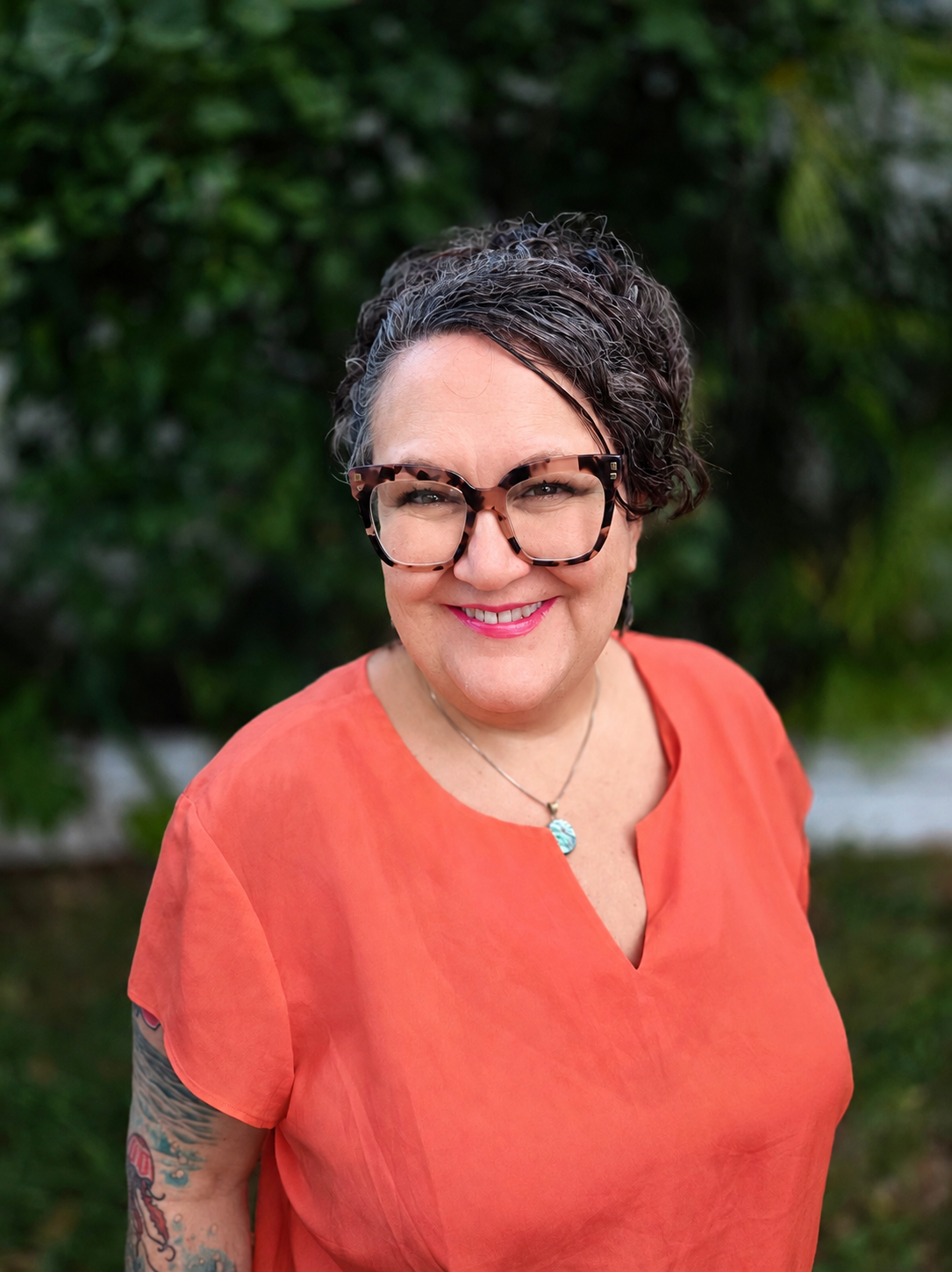 Erica Berman, LMFT, a white queer older femme-presenting therapist, smiling outdoors.